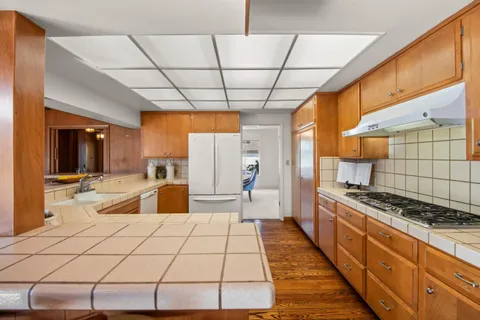 a kitchen with stainless steel appliances granite countertop a sink and a stove