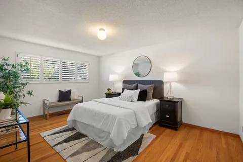 a bedroom with a bed and a painting on the wall