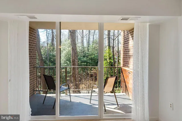 a living room with hardwood floor and floor to ceiling windows
