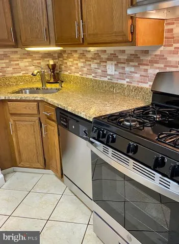 a stove top oven sitting inside of a kitchen