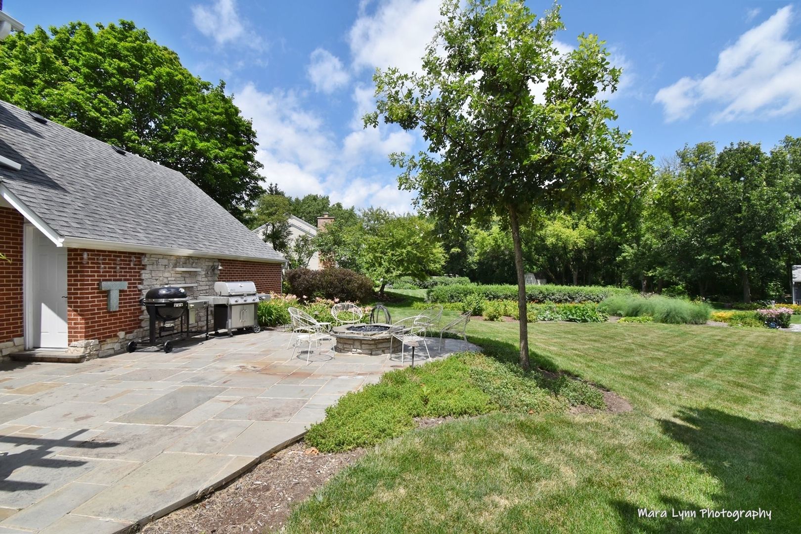 6-n143 Woodland Road St. Charles, IL 60175 - Photo 15 of 17 a view of a backyard with table and chairs under an umbrella