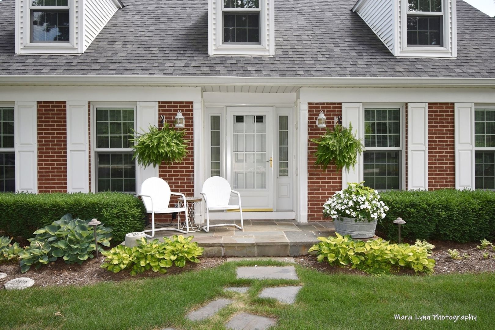 6-n143 Woodland Road St. Charles, IL 60175 - Photo 2 of 17 a front view of a house with a yard and outdoor seating