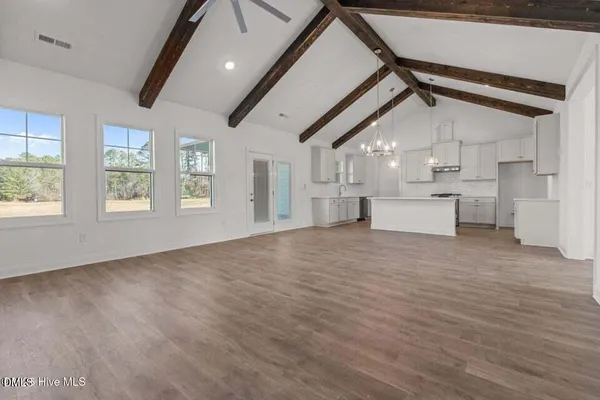 a kitchen with stainless steel appliances granite countertop a sink a stove a refrigerator and white cabinets