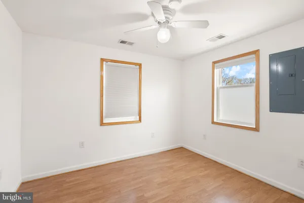 a view of a room with wooden floor a ceiling fan