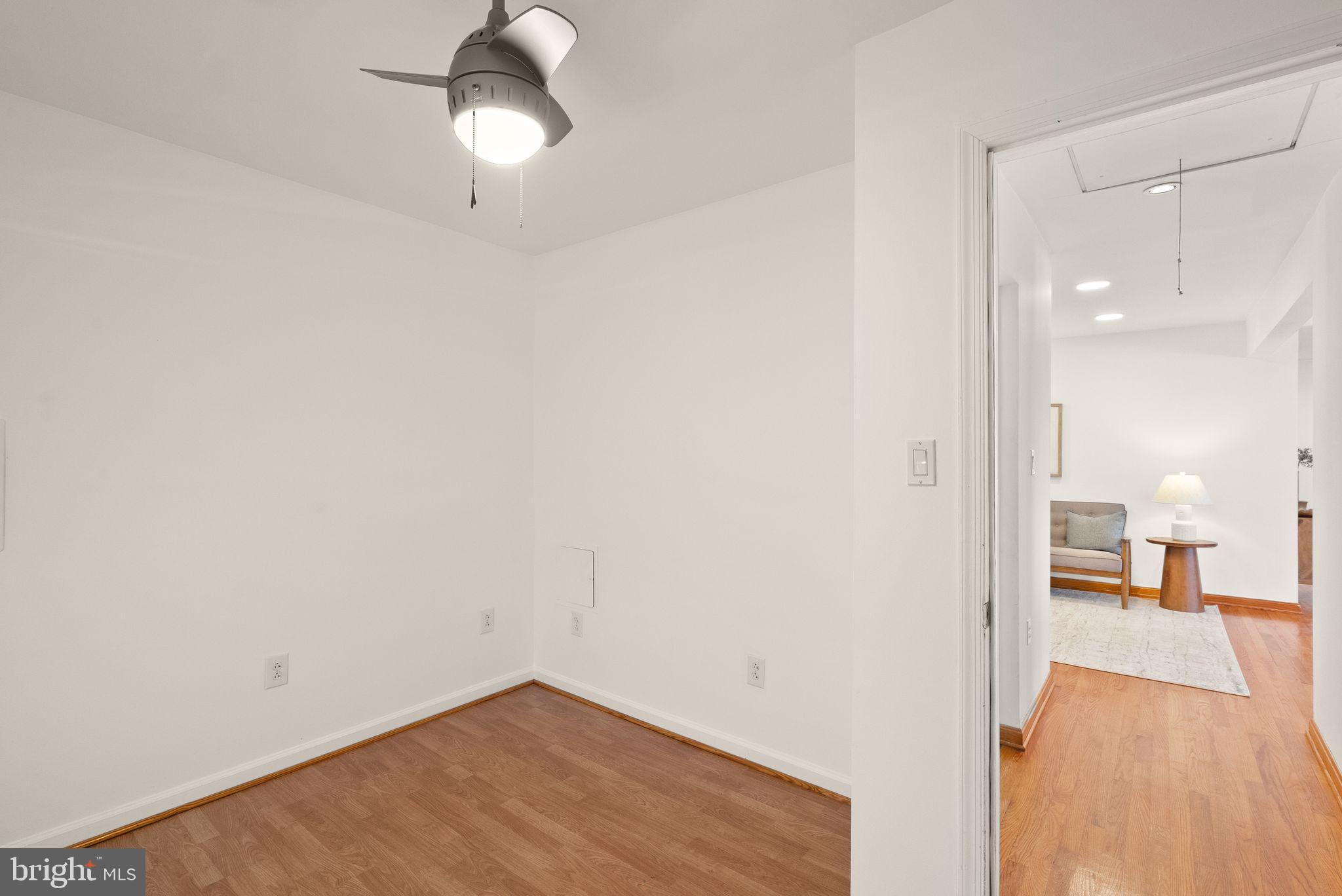8737 Redman Street Springfield, VA 22153 - Photo 34 of 62 a view of a room with wooden floor a ceiling fan