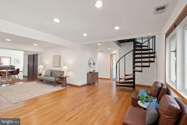 a living room with furniture and a wooden floor