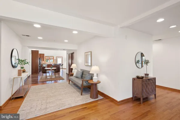 a living room with furniture a chandelier and a dining table