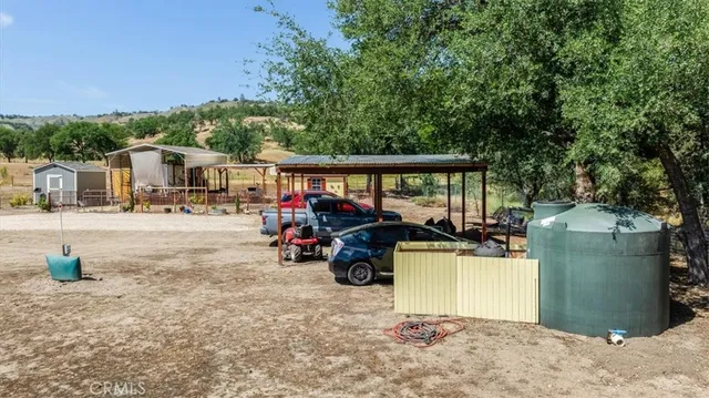 an aerial view of a house with swimming pool and large trees