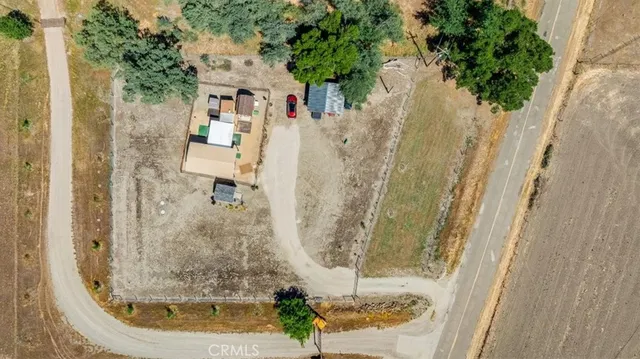 an aerial view of a house with a yard and a large parking space