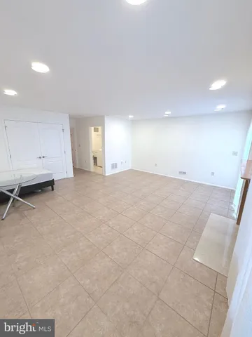 a view of an empty room with a fireplace and a window