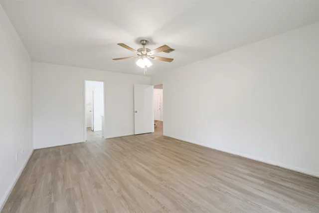 a view of empty room with wooden floor