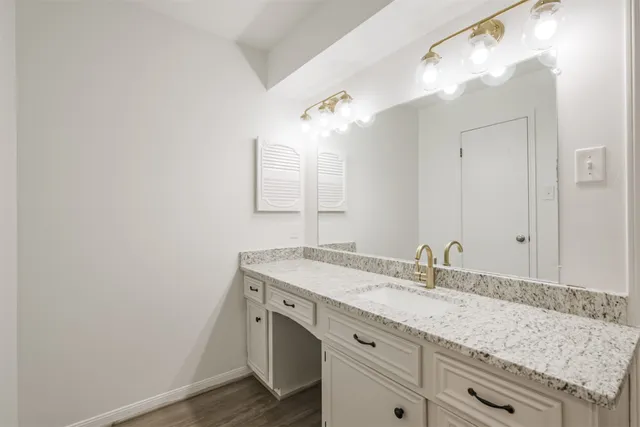 a bathroom with a granite countertop sink and a mirror