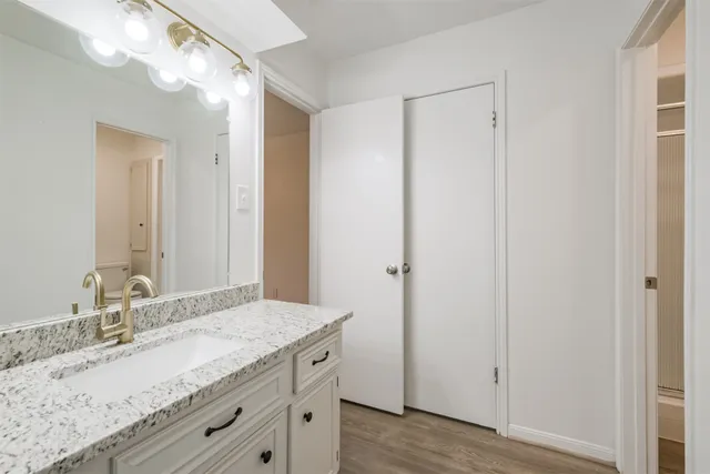 a bathroom with a granite countertop sink and a mirror