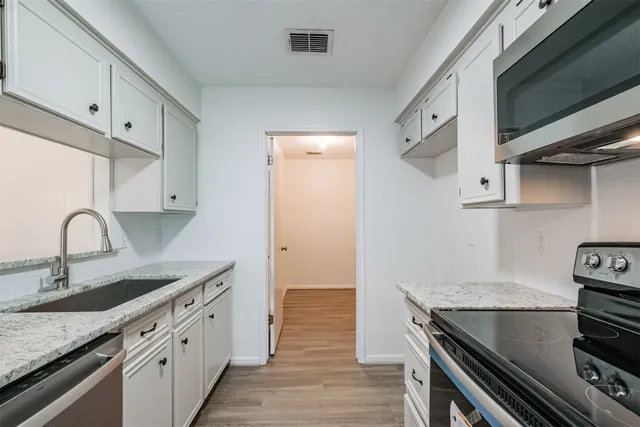a kitchen with stainless steel appliances granite countertop a sink and a stove