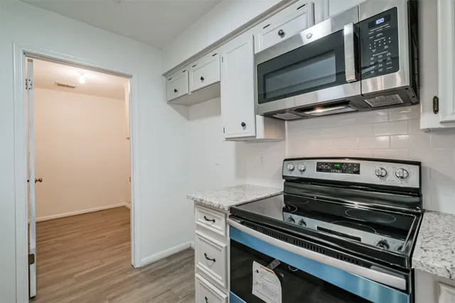 a stove top oven sitting inside of a kitchen