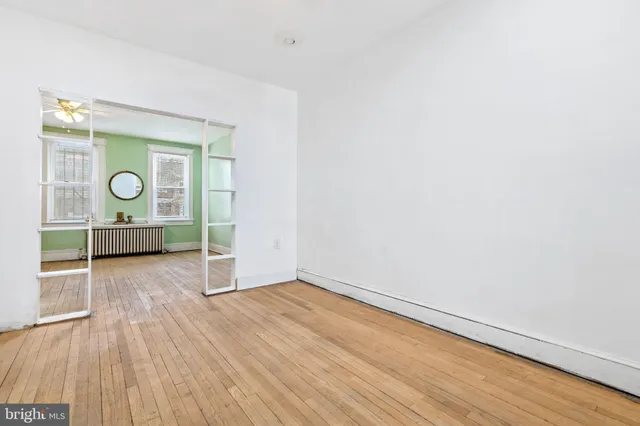 a view of empty room with wooden floor