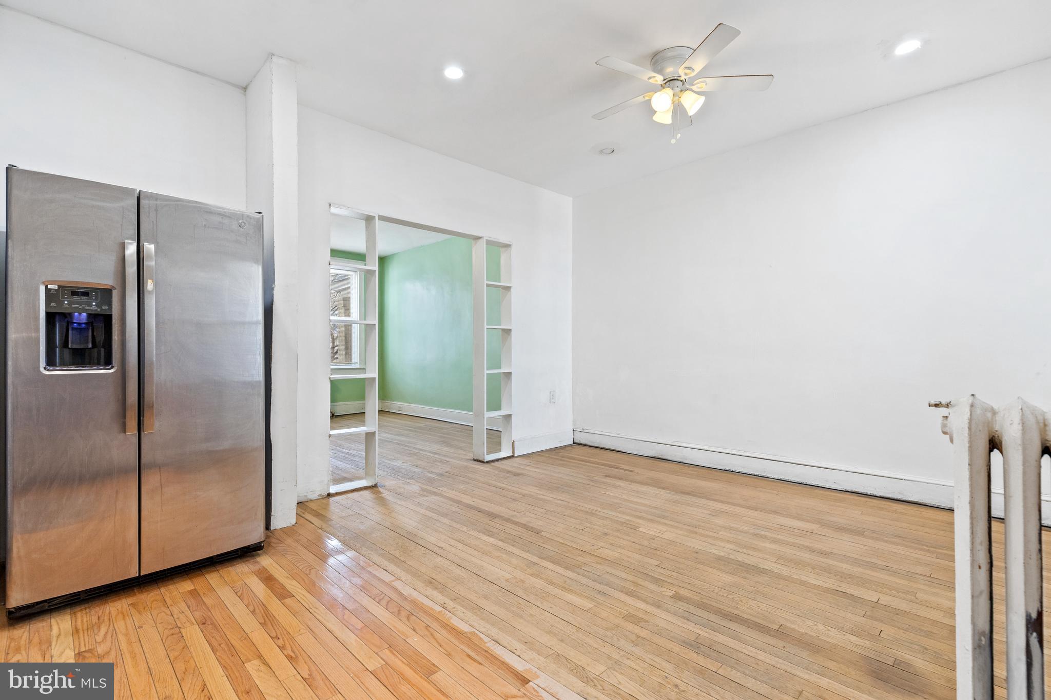 5506 8th Street Northwest Washington, DC 20011 - Photo 13 of 26 a view of a kitchen with wooden floor a ceiling fan and refrigerator in a kitchen