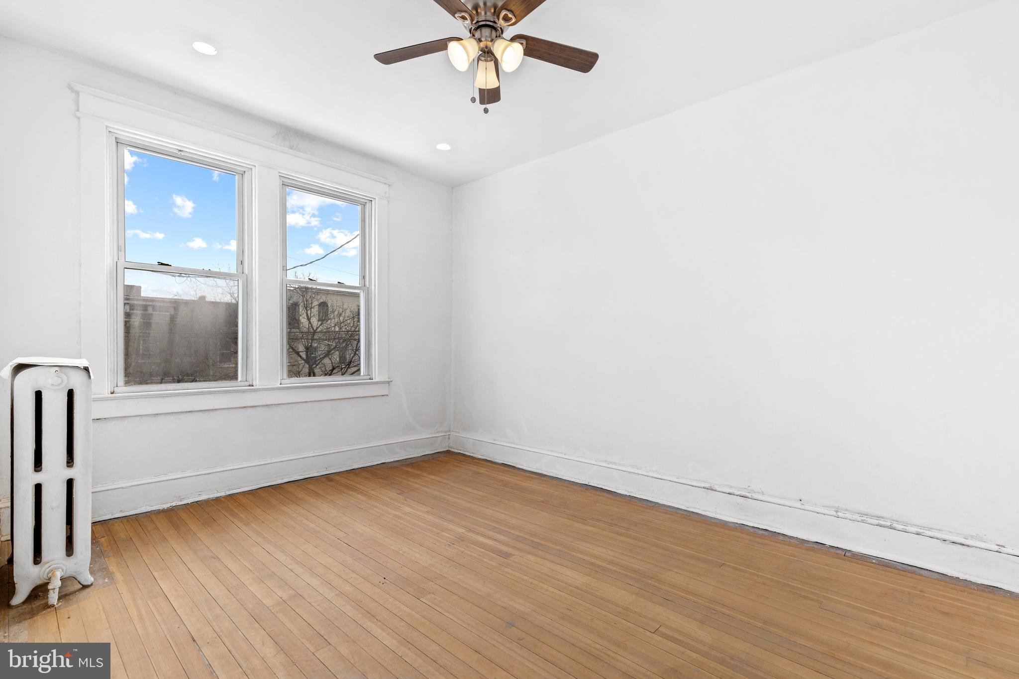 5506 8th Street Northwest Washington, DC 20011 - Photo 17 of 26 an empty room with wooden floor fan and windows