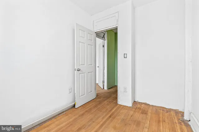 a view of a hallway with wooden floor and closet