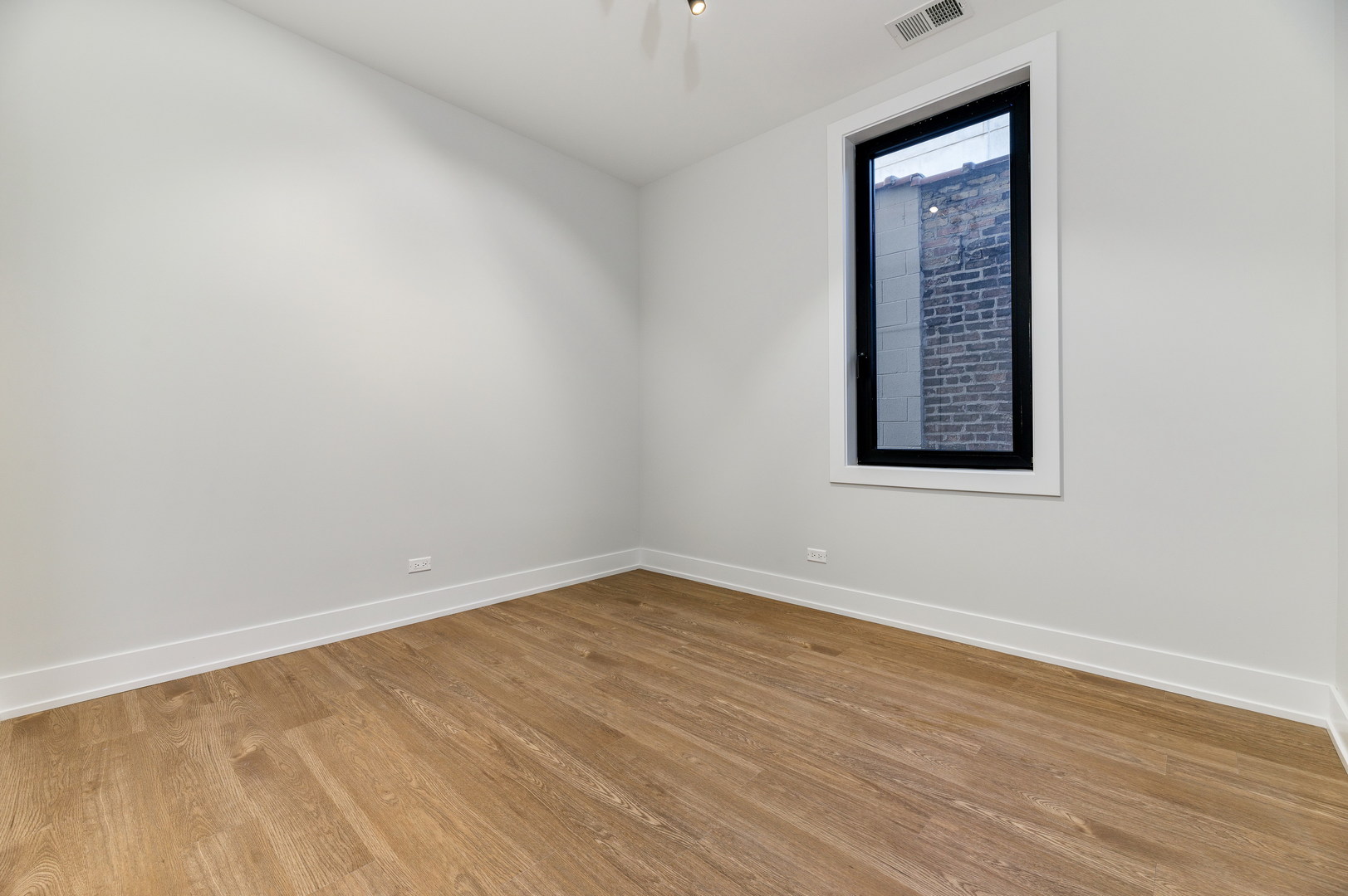 1807 West Division Street, Unit 301 Chicago, IL 60622 - Photo 11 of 15 a view of an empty room with wooden floor and a window