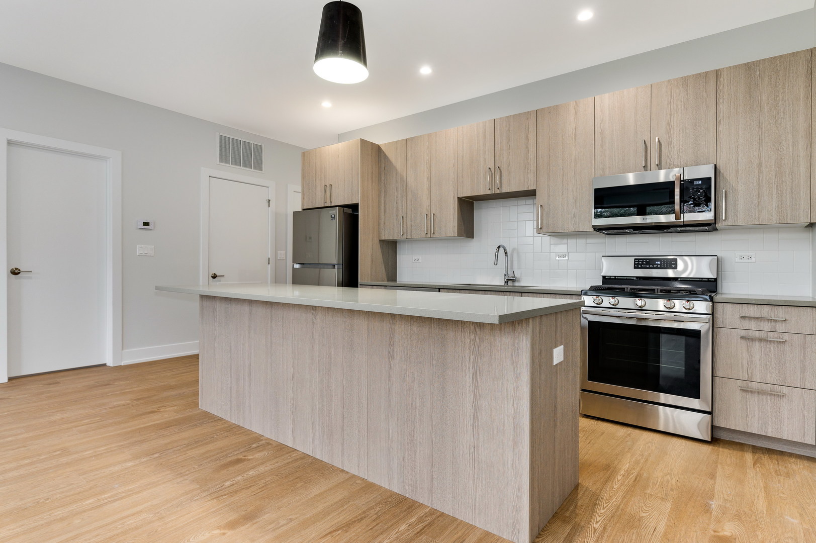 1807 West Division Street, Unit 301 Chicago, IL 60622 - Photo 2 of 15 a kitchen with stainless steel appliances granite countertop a stove a sink and a microwave