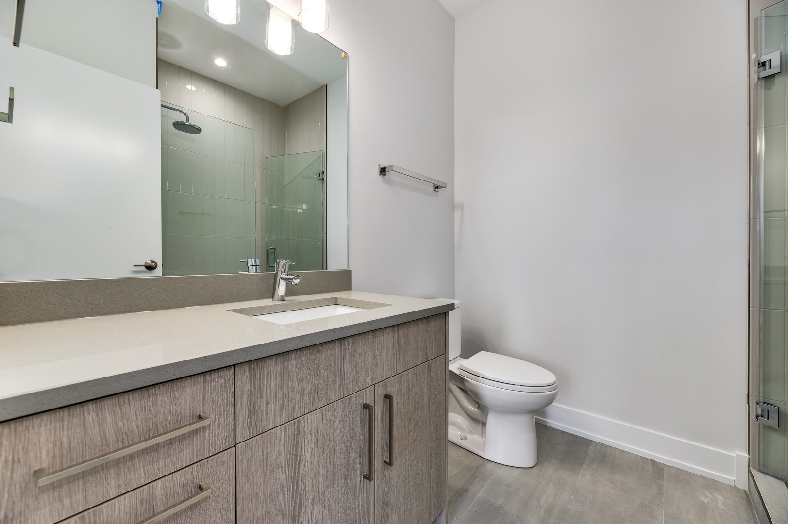 1807 West Division Street, Unit 301 Chicago, IL 60622 - Photo 9 of 15 a bathroom with a granite countertop sink a toilet and a mirror