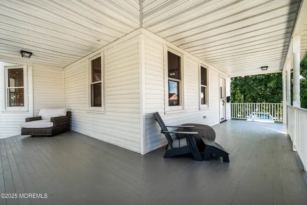 a balcony with couple of furniture and a garden