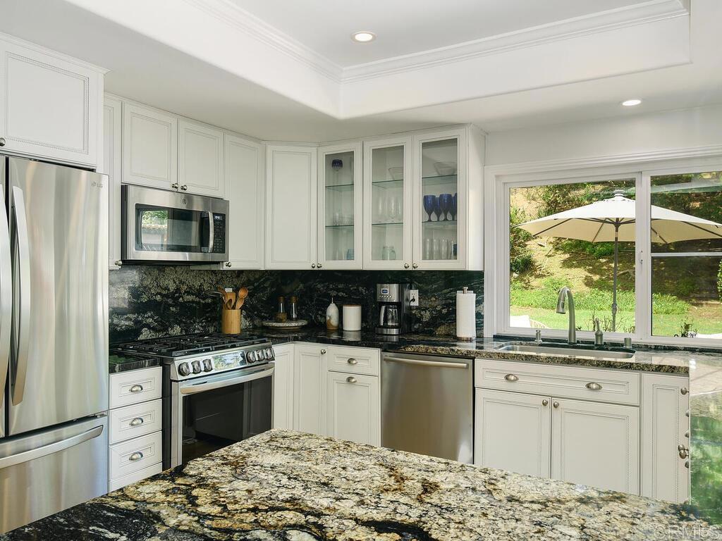 14146 Mango Drive Del Mar, CA 92014 - Photo 15 of 33 a kitchen with granite countertop a stove sink and refrigerator