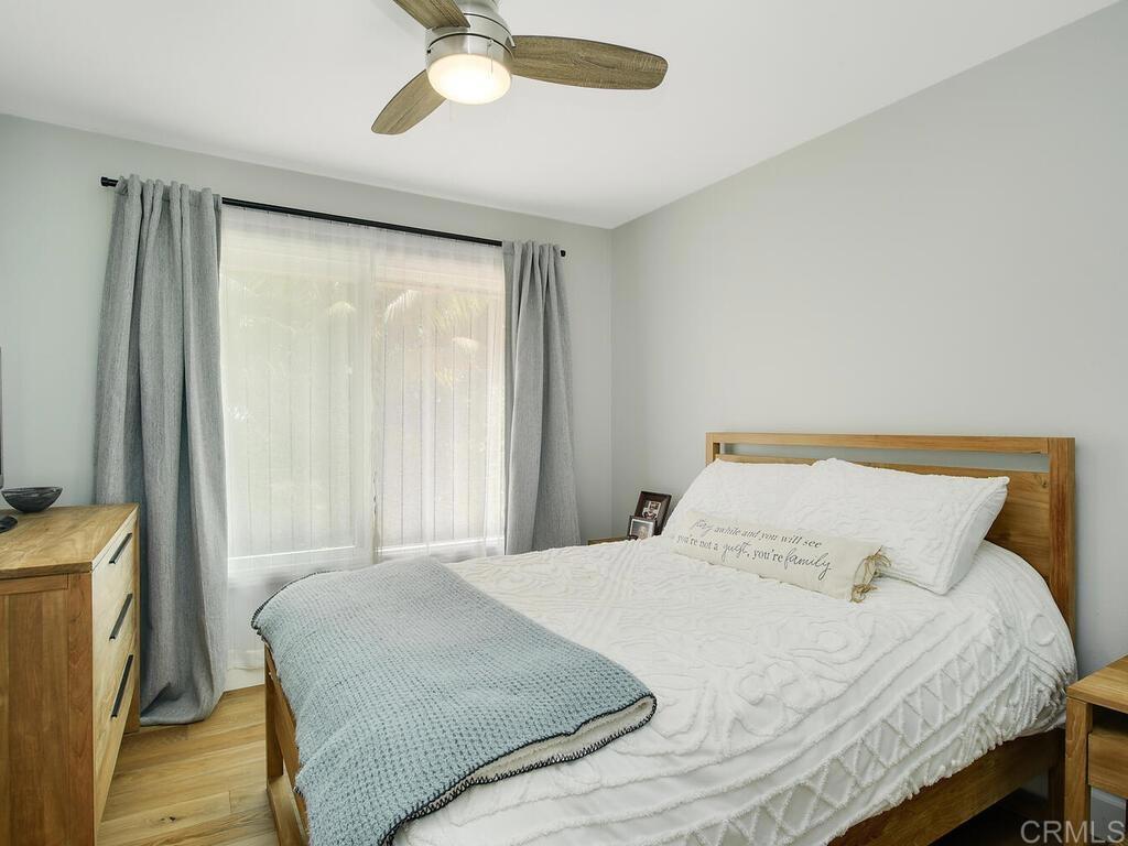 14146 Mango Drive Del Mar, CA 92014 - Photo 19 of 33 a bedroom with a bed and a chandelier