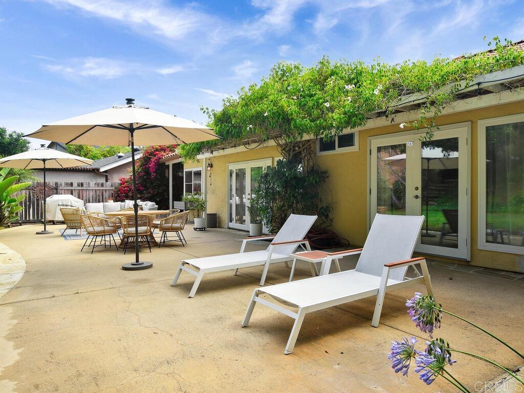 14146 Mango Drive Del Mar, CA 92014 - Photo 25 of 33 a view of a patio with a table and chairs under an umbrella