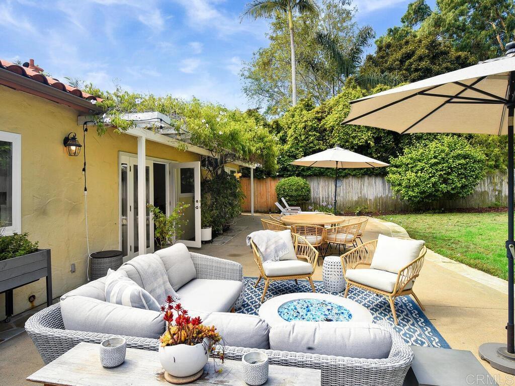 14146 Mango Drive Del Mar, CA 92014 - Photo 28 of 33 a view of a patio with couches table and chairs under an umbrella