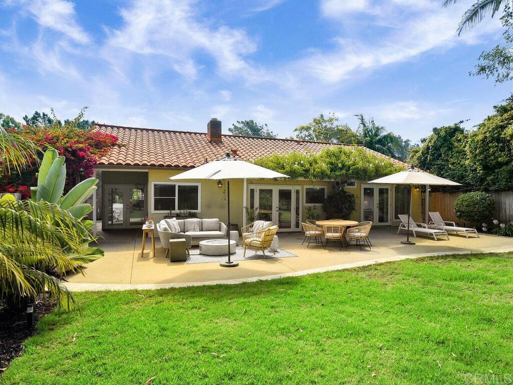 14146 Mango Drive Del Mar, CA 92014 - Photo 32 of 33 a patio with a table and chairs under an umbrella