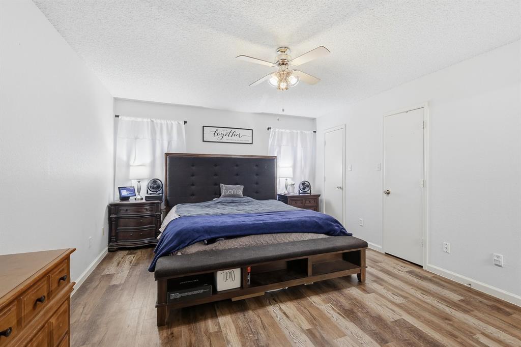 4217 Broken Arrow Road Fort Worth, TX 76137 - Photo 21 of 40 a bedroom with a bed and a chandelier