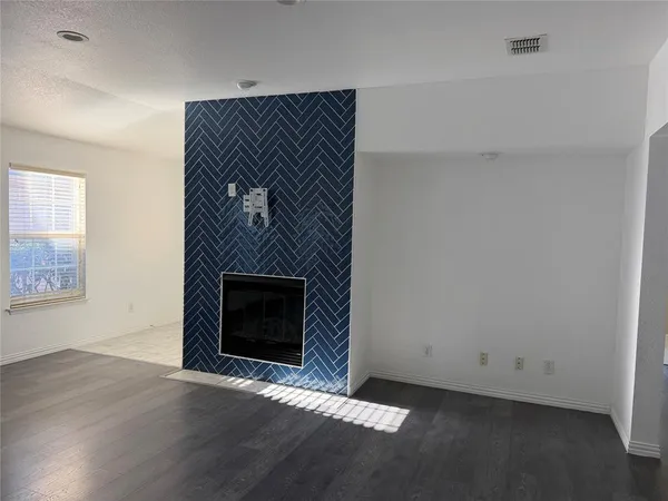 an empty room with windows and fireplace