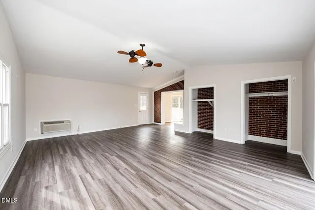 an empty room with fireplace and windows