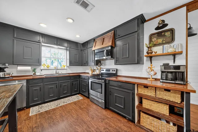 a kitchen with stainless steel appliances granite countertop wooden cabinets and sink