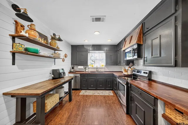 a kitchen with stainless steel appliances granite countertop a stove and a sink