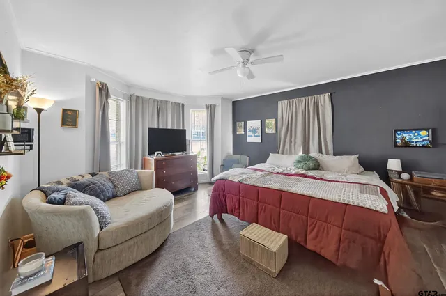 a bedroom with a bed and wooden floor