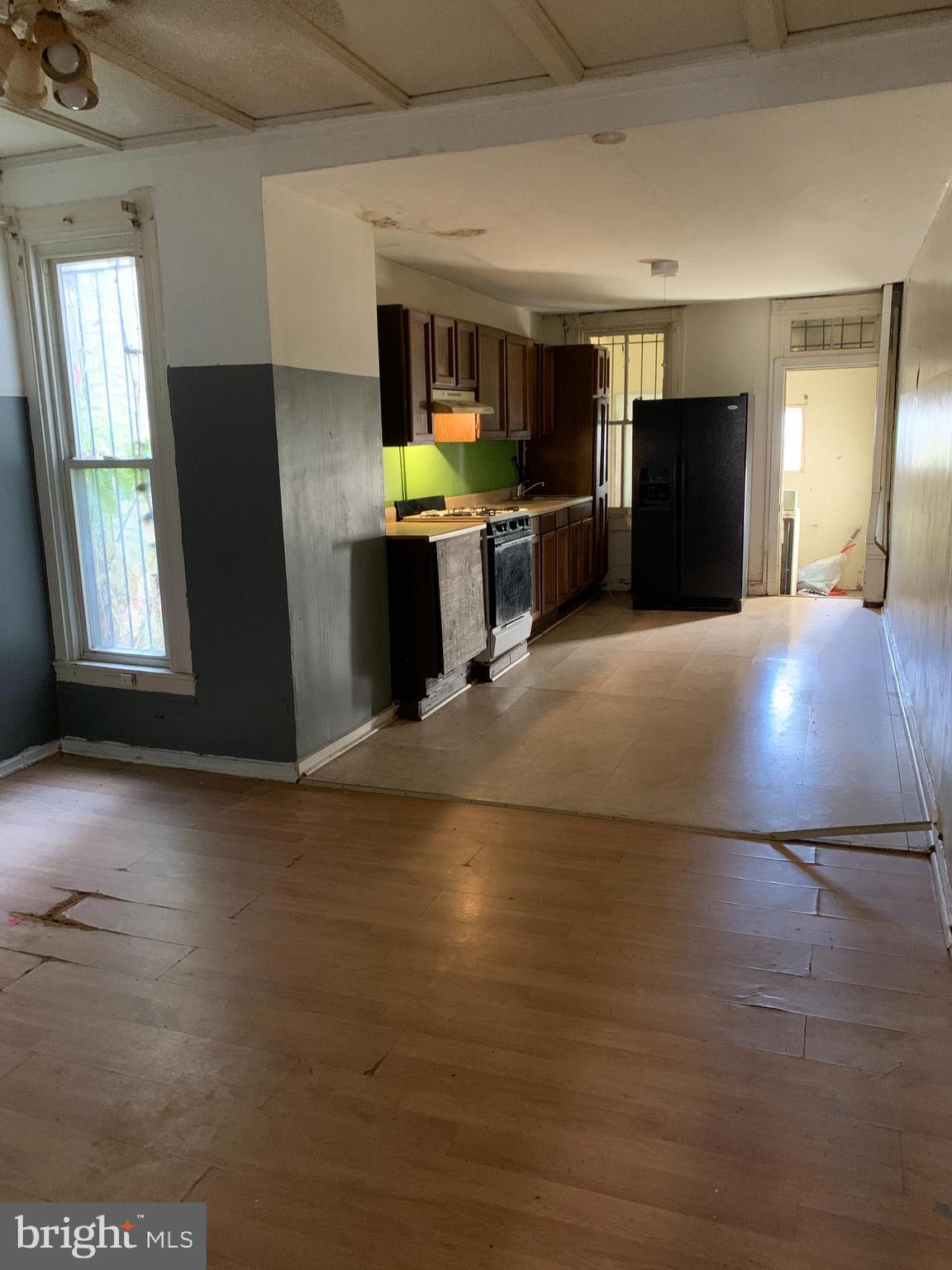 1825 Walbrook Avenue Baltimore, MD 21217 - Photo 2 of 13 a kitchen with granite countertop a refrigerator and a stove top oven