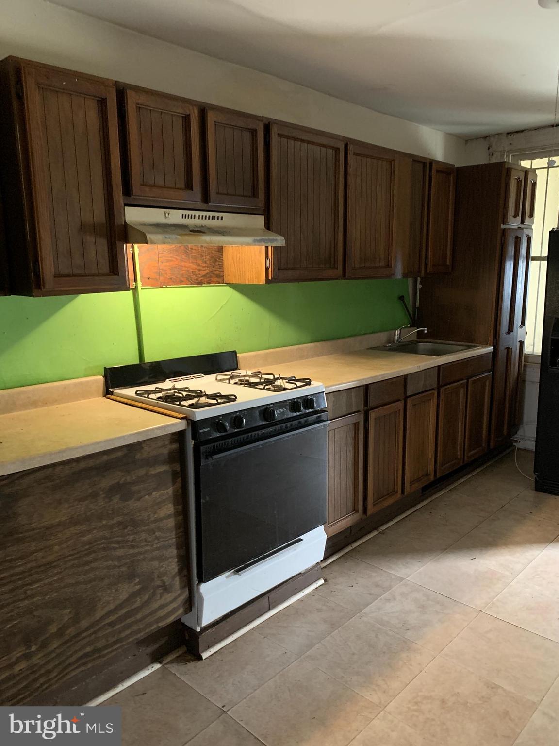 1825 Walbrook Avenue Baltimore, MD 21217 - Photo 3 of 13 a kitchen with granite countertop a stove and a cabinets