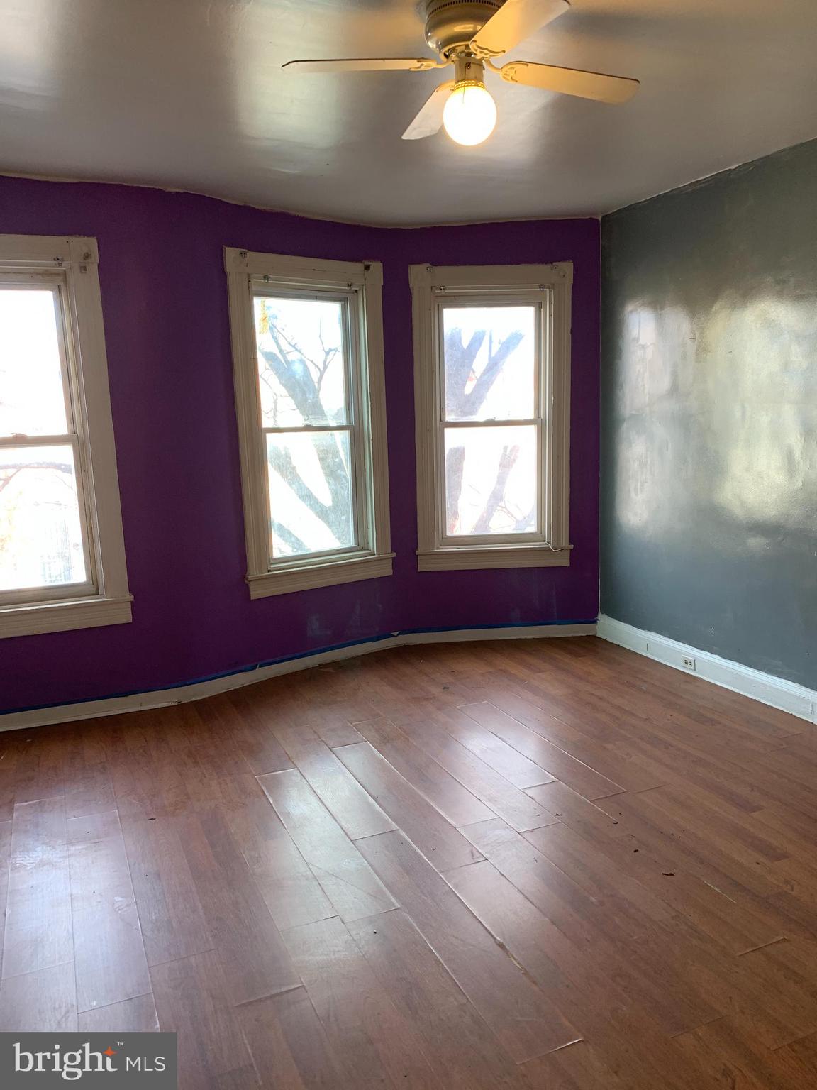1825 Walbrook Avenue Baltimore, MD 21217 - Photo 8 of 13 an empty room with wooden floor and windows
