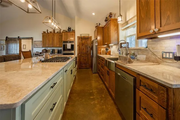 a kitchen with stainless steel appliances granite countertop a sink a oven and a counter space