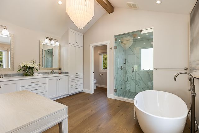 a spacious bathroom with a bathtub sink and mirror