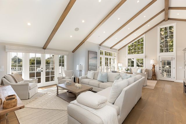 a living room with furniture and floor to ceiling windows