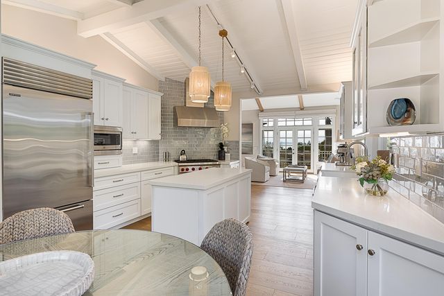 a living room with stainless steel appliances kitchen island granite countertop a sink a stove and a window