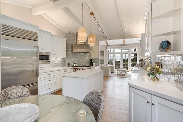 a living room with stainless steel appliances kitchen island granite countertop a sink a stove and a window