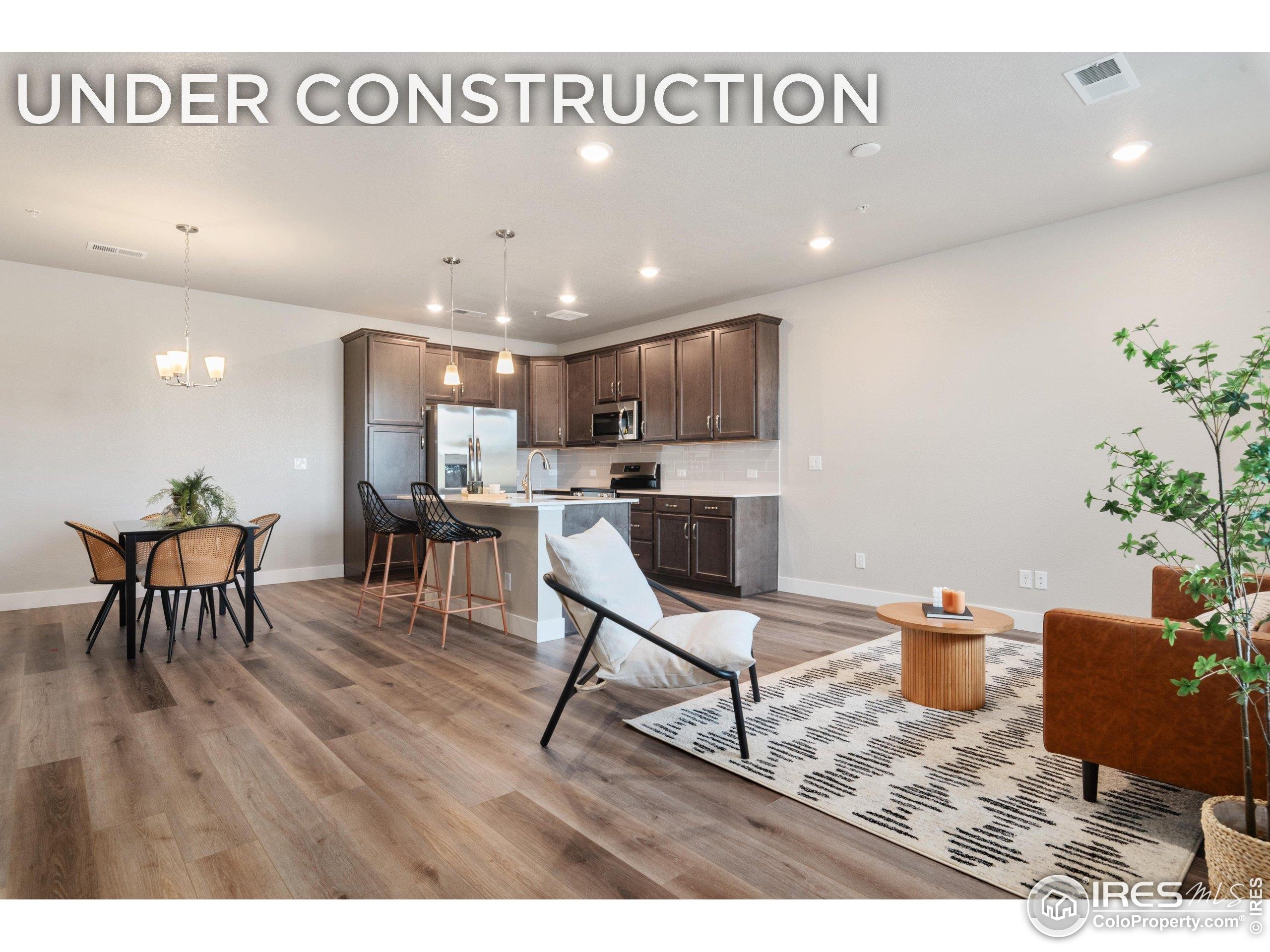 6793 Maple Leaf Drive, Unit 101 Timnath, CO 80547 - Photo 1 of 11 a living room with furniture and a dining table with wooden floor