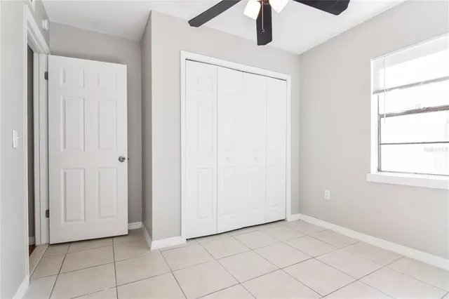 an empty room with chandelier fan