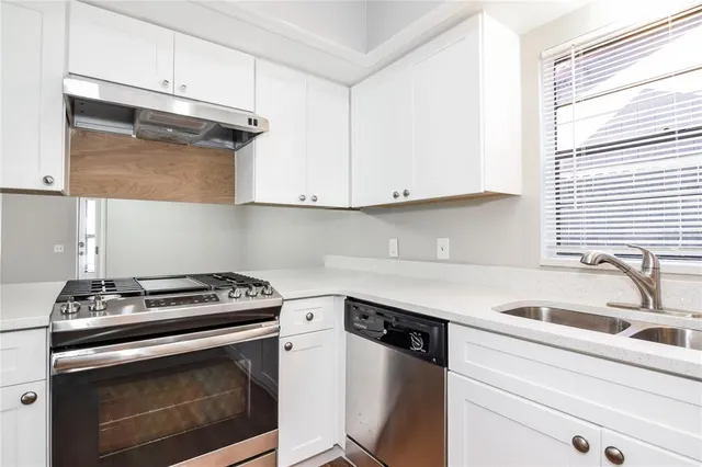 a kitchen with granite countertop cabinets stainless steel appliances and sink