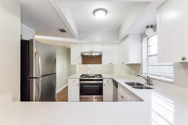 a kitchen with a sink a refrigerator and a stove top oven